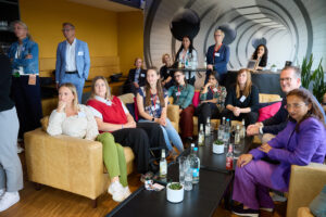 Teilnehmende einer After-Work-Veranstaltung diskutieren in einer modernen Lounge über Gender Audit und Unternehmensvielfalt
