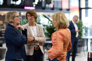 Drei Frauen im Business-Umfeld sprechen über die Frauenquote, mit Fokus auf gesetzliche Regelungen und aktuelle Entwicklungen.